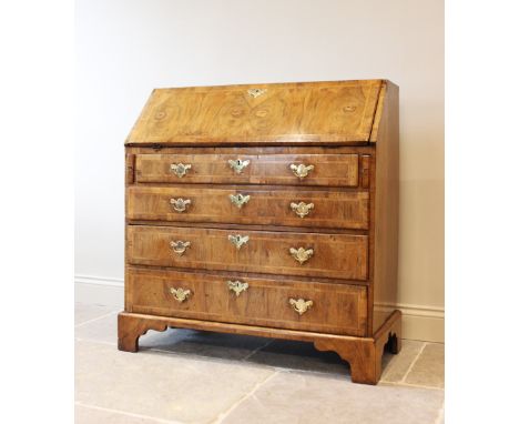 A mid 18th century figured walnut bureau, the veneer fall front enclosing a central door flanked by small drawers and pigeon 