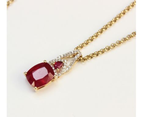 A ruby and diamond pendant, designed as a central cushion shaped untested ruby measuring 11mm x 9mm, surmounted by a further 