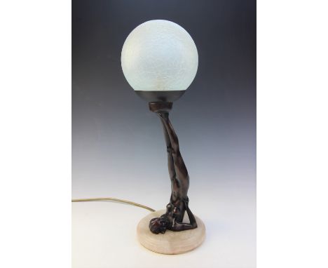 An Art Deco style bronzed figural lamp base, modelled as a nude figure supporting a spherical craquelure shade, 46cm high Lig