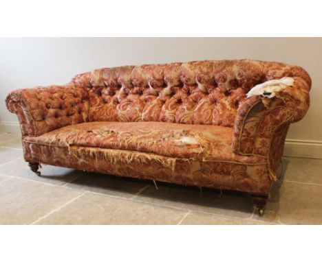 A 19th century button back chesterfield type sofa, upholstered in foliate fabric and raised on turned walnut feet, on castors