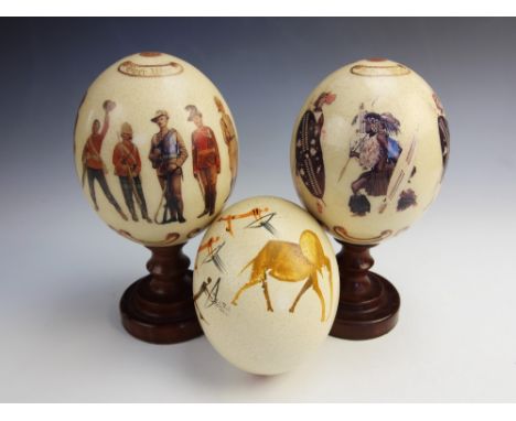 Two printed ostrich eggs, one decorated with Zulu warriors and text 'Zulu War' and '1879', the other with  soldiers in variou