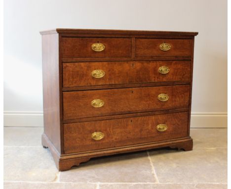 A George III oak and mahogany cross banded chest of drawers, the top inlaid with barber pole stringing above two short and th