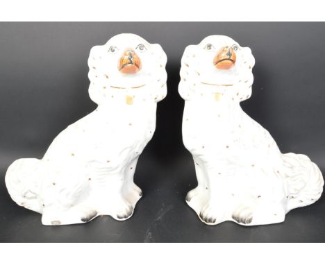 A pair of vintage 20th Century ceramic fire side mantel Staffordshire spaniel dogs. Having gilt coloured collars and chains w