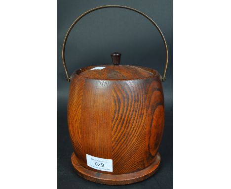 A vintage 20th Century oak biscuit barrel. Having a metal carry handle, circular body with wooden lid with a ceramic jar insi