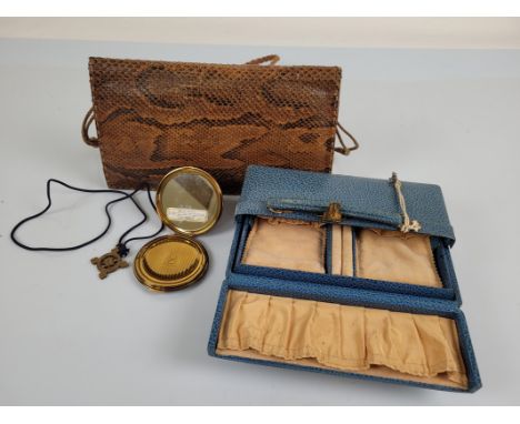 A blue leather jewellery box, with central open section which lifts out, together with a snake skin handbag and a Stratton co