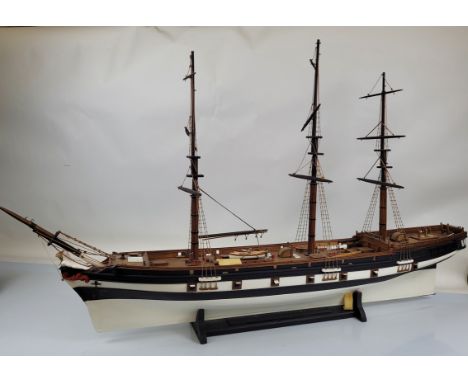 A large wooden ship model, with stand approx 95cm tall x 150cm long.