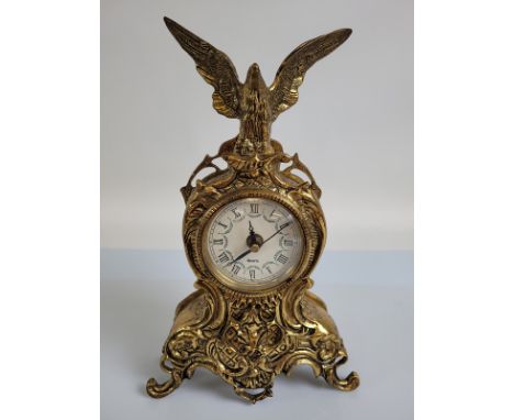 A lacquered brass mantel clock, surmounted by an eagle, 34cm high with quartz movement