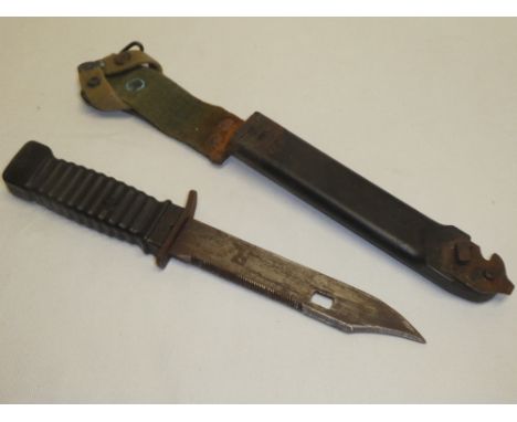 A post War survival knife with single edged blade in composition scabbard with barbed wire cutting attachment