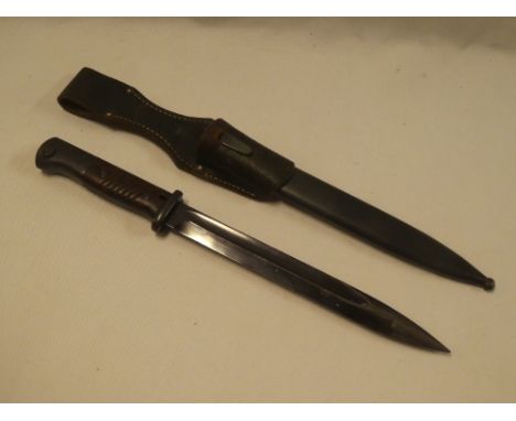 A German model K98 bayonet with blackened steel blade, Waffen markings and bakelite grips in steel scabbard with leather frog