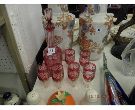 A cranberry glass decanter and six glasses