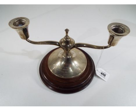 A twin arm hallmarked silver candlestick on wooden plinth, Sheffield assay with engraved dedication dated 1959, approximately