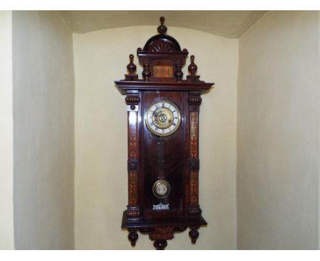 A Vienna style spring driven wall clock, the stained beech case having turned and carved decoration along with Arts & Crafts 