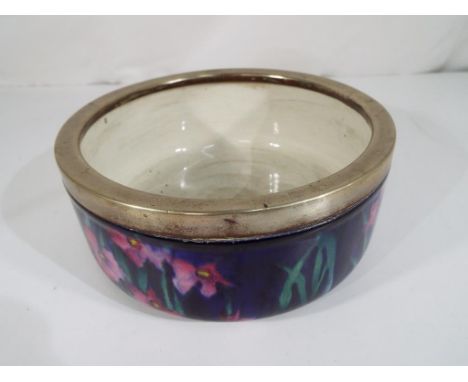 George Jones - a George Jones Imperial Rouge bowl with a white metal rim decorated in a floral pattern on a mottled deep blue