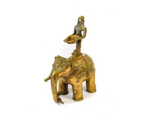 A South-East Asian Bronze Figural Lamp, as a female deity standing on the back of an elephant holding a bowl29cm highA Simila