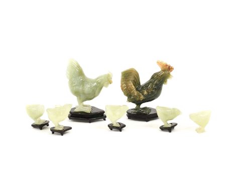 A Chinese Jade Family of Hens, the naturalistically carved birds comprising a cockerel, hen and five chicks, with hardwood st