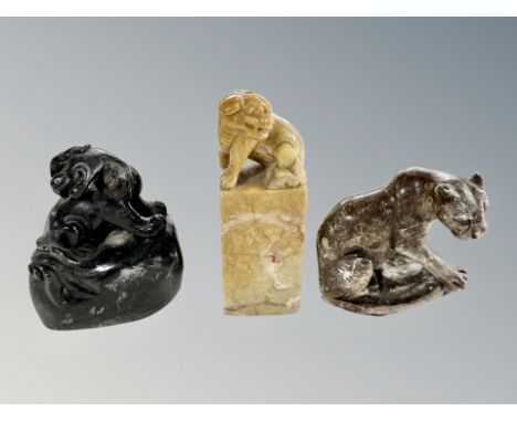 A Chinese carved soapstone scroll weight in the form of a foo dog, height 12 cm, together with two further Chinese carvings 