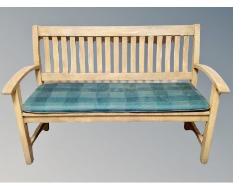 A teak garden bench with cushion, width 140 cm