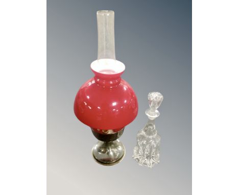 A 20th century oil lamp with red glass shade together with a crystal mallet decanter 