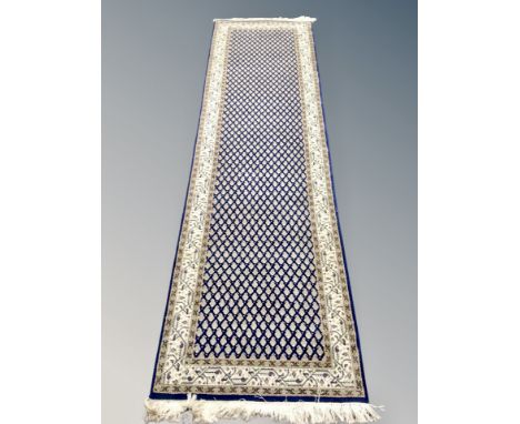 A Ghom design runner, on indigo ground, 313 cm x 80 cm 