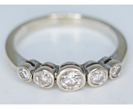 An 18ct white gold five stone bezel set diamond ring, the central round brilliant cut diamond approx. 0.20 carats, total appr