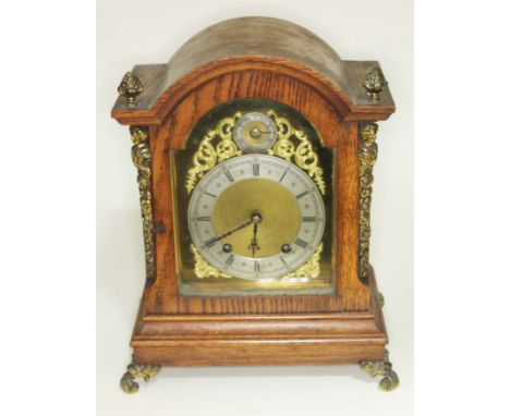 A gilt brass mounted domed oak mantle clock, brass and steel dial with Roman numerals, height 33.5cm.  