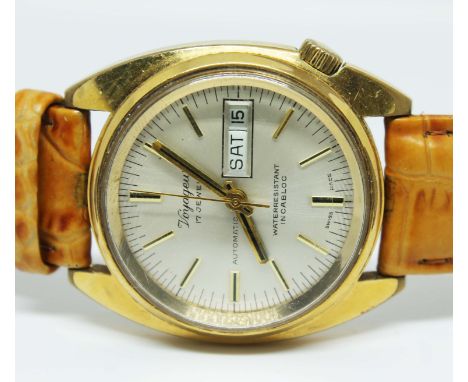 A gent's Voyageur automatic gold tone stainless steel wristwatch on leather strap, the silvered dial having gold coloured num