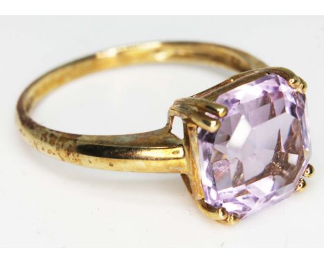 A 9ct gold ring set with a large amethyst coloured paste stone, marked '9K', gross wt. 3.6g, size V, with box.  