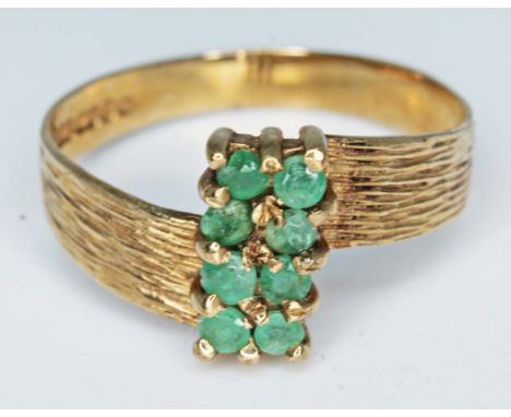 A hallmarked 9ct gold ring set with eight green stones, gross wt. 1.8g, size M.  