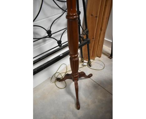 A traditional mahogany standard lamp having turned column and triple splay legs