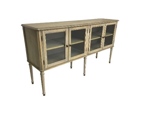 Washed finish sideboard or dresser, rectangular top over four glazed cupboard doors enclosing single shelf, raised on fluted 