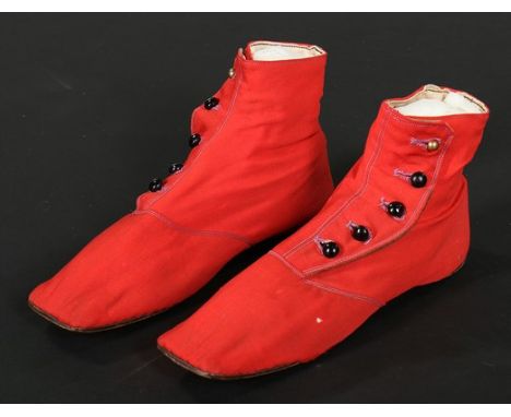 A pair of chisel-toed scarlet wool ankle boots, circa 1850, with black glass and brass side buttons, flat, straight soles, 'M