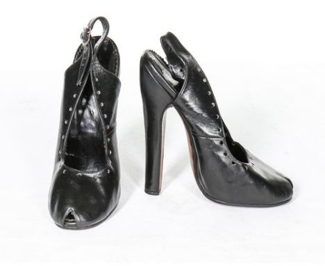 A pair of black leather fetish shoes, 1930s, peep-toed with perforated edges and vertiginous 16cm heels, approximately UK siz