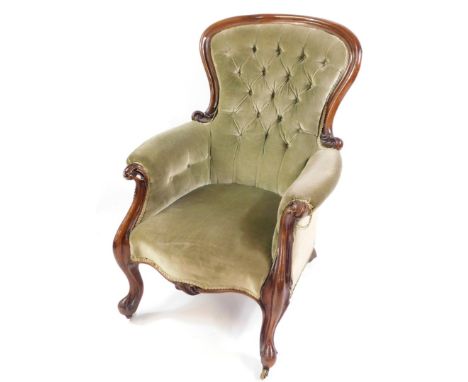 A Victorian mahogany spoon back nursing chair, upholstered in green button back fabric, raised on cabriole legs on castors.