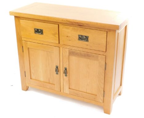 A light oak sideboard, with two drawers over a pair of cupboard doors, raised on block feet, 86cm high, 105cm wide, 44cm deep