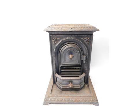 A Victorian cast iron wood burner, of rectangular section, the front arch door opening to reveal an interior with grate, abov