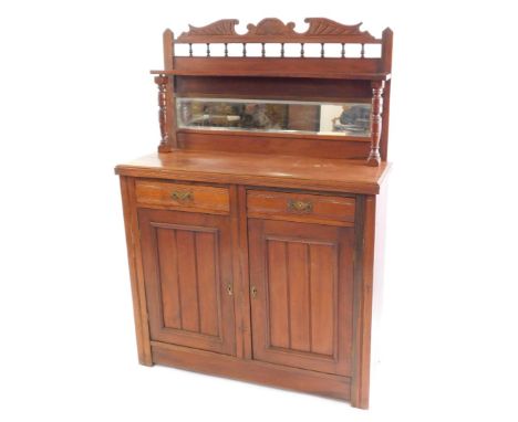A Victorian mahogany chiffonier, with a carved and broken arch pediment, over a single shelf, raised on turned supports, with