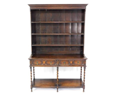 A 17thC style oak dresser, the outswept pediment over three shelf plate rack, above two panelled drawers, raised on spiral tw