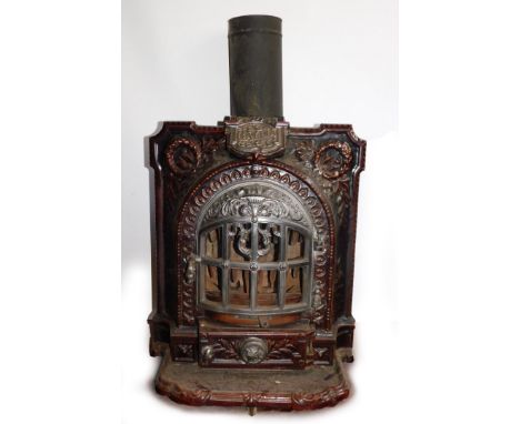 A French late 19thC cast iron and brown enamel Gallia stove, of bow fronted form, embossed with laurel wreaths and flaming to