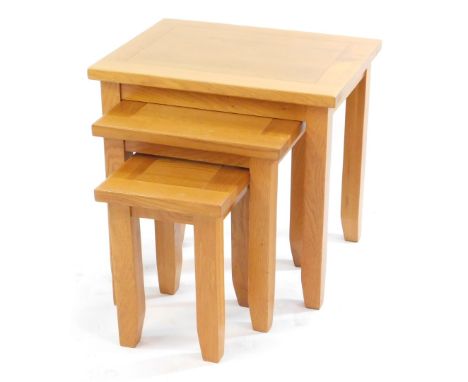 A light oak nest of occasional tables, raised on square legs, largest 50cm high, 54cm wide, 42cm deep.