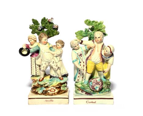 A pair of Staffordshire pearlware figure groups, c.1800, of squabbling children, each modelled with a central boy being set u