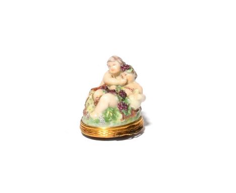 A Chelsea bonbonniere, c.1760, modelled with a putto feeding wine to a reclining infant Bacchus draped in grapevine, the pair