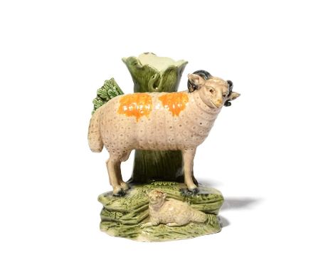 A Staffordshire pearlware spill vase, c.1800, modelled with a sheep standing over a recumbent lamb before a hollow tree trunk