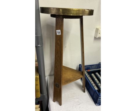 An arts &amp; crafts oak tripod table with hammered brass top