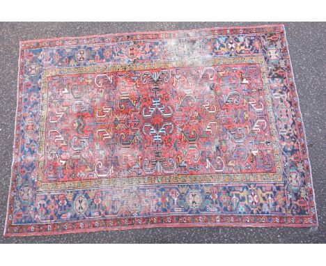 Early 20th Century Persian Heriz carpet, the coral field with all-over scroll decoration, within an indigo stylised floral bo