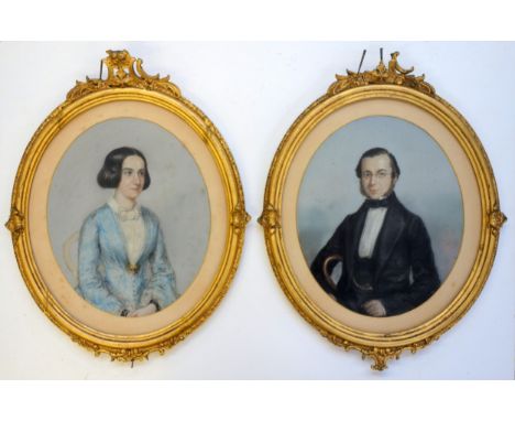 19th century pastel portraits of a female in blue dress and a male in black with bow tie, each set within a gilt frame (damag