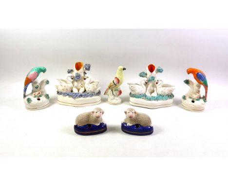 Pair of Victorian Staffordshire pottery quill holders, each modelled as a parakeet perched on a tree stump with a lamb below,