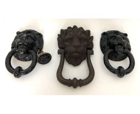 A cast iron door knocker, in the form of a lion's head, 22 cm high, and a pair of door knockers in the form of lion's heads, 