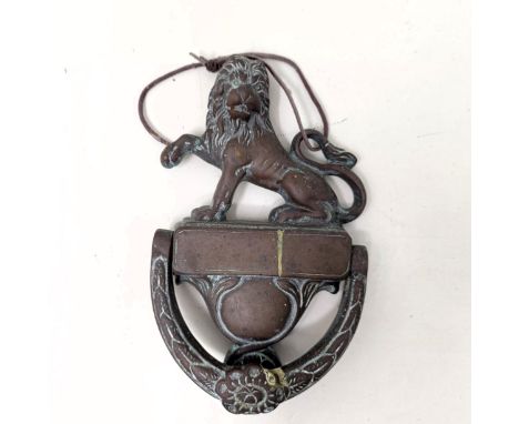 A bronze door knocker, with a lion finial, 25 cm high 