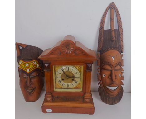 A mantel clock, in a walnut case, 42 cm high, two African masks, and assorted other items (box) 