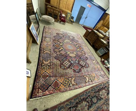 Large 20th Century wool rug decorated with a central geometric panel on a principally blue background, 405 x 304cm